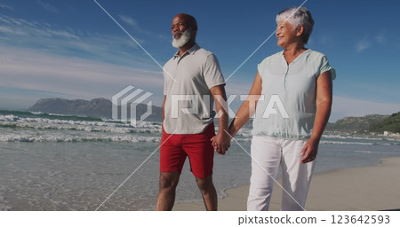 Senior biracial woman and African American man walk on the beach Senior biracial woman and African American man walk on the beach 123642593
