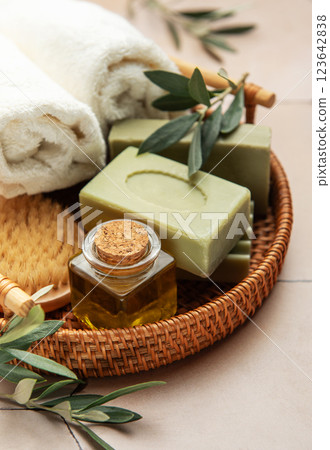 Olive oil soap, essential oil and white towel promoting natural body care and hygiene Olive oil soap, essential oil and white towel promoting natural body care and hygiene 123642838