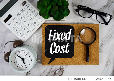 Fixed Cost text on speech bubble with alarm clock, calculator and magnifying glass on marble background 123642976