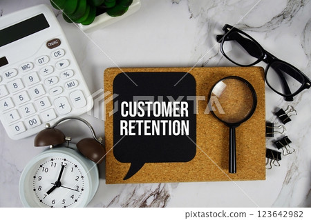 Customer Retention text on speech bubble with alarm clock, calculator and magnifying glass on marble background Customer Retention text on speech bubble with alarm clock, calculator and magnifying glass on marble background 123642982