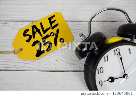 Sale 25% on price tag with alarm clock on wooden background Sale 25% on price tag with alarm clock on wooden background 123643061