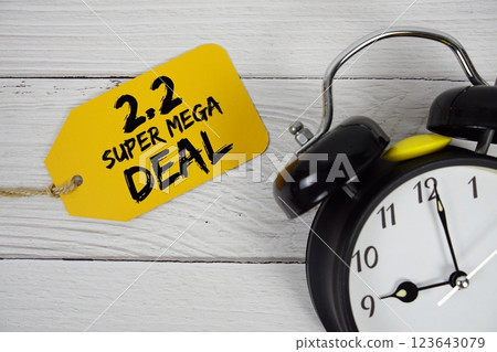 2.2 Super Mega Deals Promotion on price tag with alarm clock on wooden background 2.2 Super Mega Deals Promotion on price tag with alarm clock on wooden background 123643079