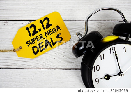 12.12 Super Mega Deals Promotion on price tag with alarm clock on wooden background 12.12 Super Mega Deals Promotion on price tag with alarm clock on wooden background 123643089