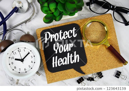 Protect Your Health text on speech bubble with alarm clock, magnifying glass and stethoscope on marble background Protect Your Health text on speech bubble with alarm clock, magnifying glass and stethoscope on marble background 123643139