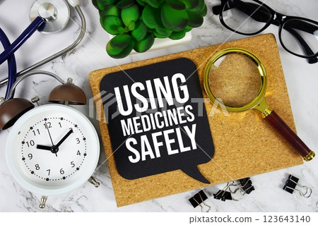 Using Medicines Safely text on speech bubble with alarm clock, magnifying glass and stethoscope on marble background Using Medicines Safely text on speech bubble with alarm clock, magnifying glass and stethoscope on marble background 123643140