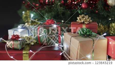 Wrapped gifts sit under a festive Christmas tree, with copy space 123643219