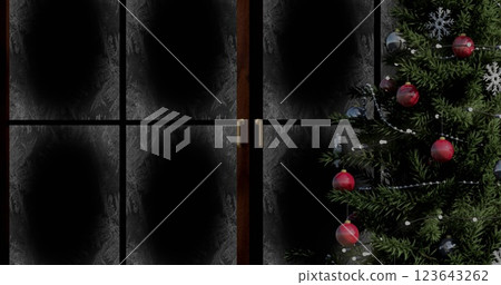 Image of snow falling over christmas tree and fairy lights flickering in winter window 123643262