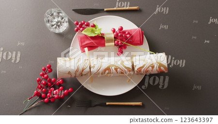 Image of christmas greetings text over christmas cracker and place setting with decorations Image of christmas greetings text over christmas cracker and place setting with decorations 123643397