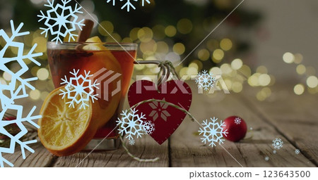 Image of snow falling over christmas drink and decorations 123643500