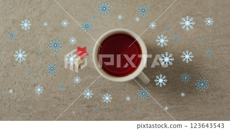 Image of snow falling over christmas cup of tea 123643543