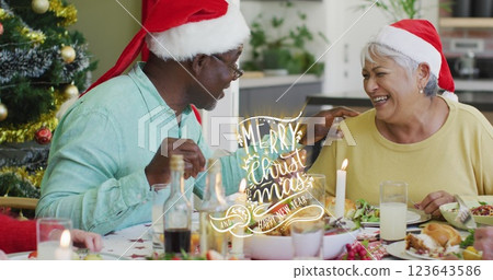 Image of christmas greetings text over senior diverse friends at christmas meal table Image of christmas greetings text over senior diverse friends at christmas meal table 123643586