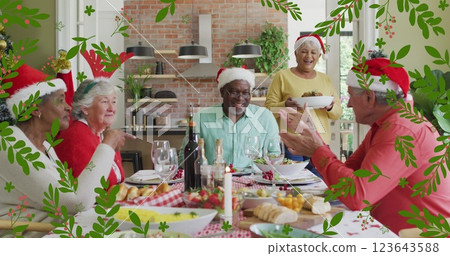 Image of christmas holly over senior diverse friends in santa hats at christmas meal table Image of christmas holly over senior diverse friends in santa hats at christmas meal table 123643588