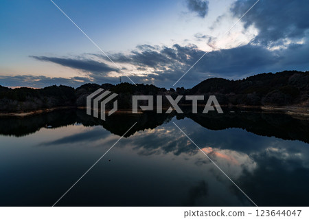 The temperature is rising and it's starting to feel like spring at Nara Nunome Dam. The beautiful sunset reflected on the lake surface. The temperature is rising and it's starting to feel like spring at Nara Nunome Dam. The beautiful sunset reflected on the lake surface. 123644047