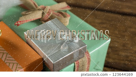 Image of merry christmas text over snow falling with christmas presents 123644169