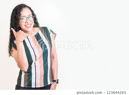 Latin woman in glasses gesturing call with fingers isolated. Happy girl in glasses gesturing call me with hand isolated 123644263