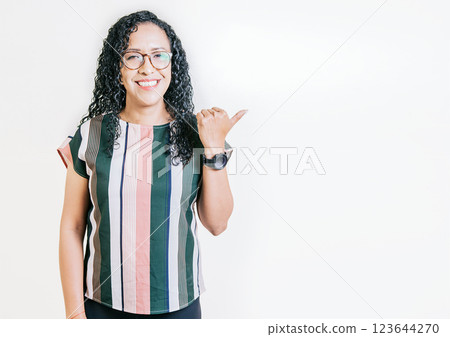 Smiling latin people pointing to a banner to the side. Happy latin woman recommending with fingers isolated. Cheerful curly haired girl pointing an offer Smiling latin people pointing to a banner to the side. Happy latin woman recommending with fingers isolated. Cheerful curly haired girl pointing an offer 123644270