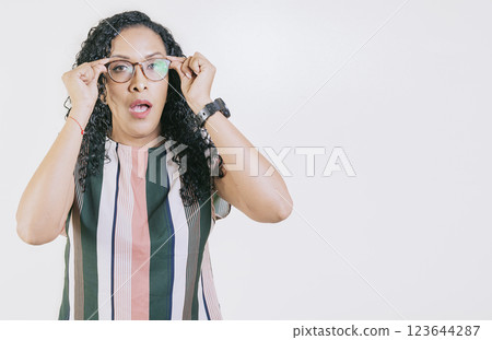 Surprised woman taking off glasses isolated. Amazed afro girl taking off glasses by a promotion, man opening his mouth surprised taking off his glasses 123644287