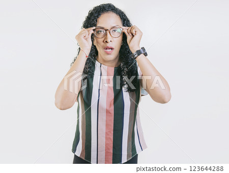 Latin girl taking off her glasses looking a promotion. Surprised woman taking off glasses isolated. Amazed afro girl taking off glasses by a promotion 123644288