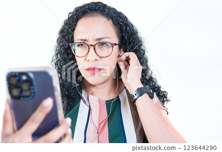 Young afro woman listening to music with headphones isolated. Close up of afro girl listening songs with celphone on isolated background 123644290