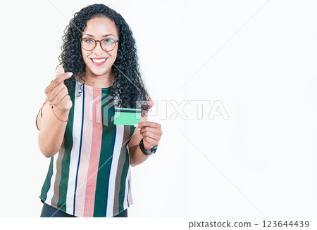 Happy afro girl in glasses holding credit card making money gesture with fingers, looking at camera isolated 123644439