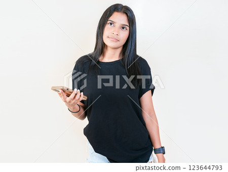 Pensive latin girl holding smart phone on white background. Thoughtful attractive girl holding phone isolated Pensive latin girl holding smart phone on white background. Thoughtful attractive girl holding phone isolated 123644793