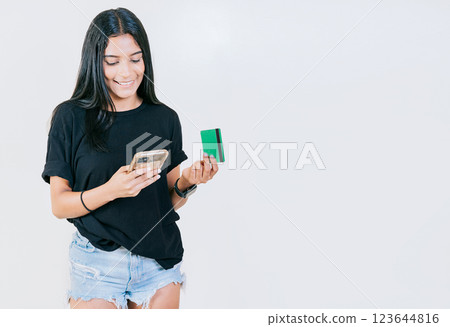 Girl holding credit card shopping online with cell phone isolated. People making online purchases with cell phones and credit cards isolated Girl holding credit card shopping online with cell phone isolated. People making online purchases with cell phones and credit cards isolated 123644816