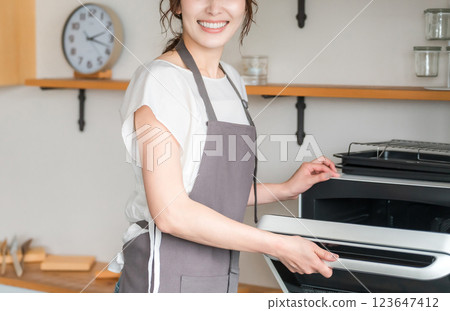 Woman using a microwave in the kitchen (no face) 123647412