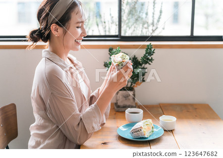 亞洲女性在咖啡館吃三明治當午餐/早午餐/早餐 123647682