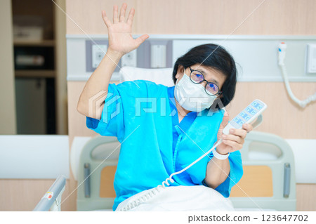 Elderly asian Woman patient hand using remote control for adjust level bed in hospital room. Happy Senior illness resting on comfortable electric bed in modern hospital 123647702