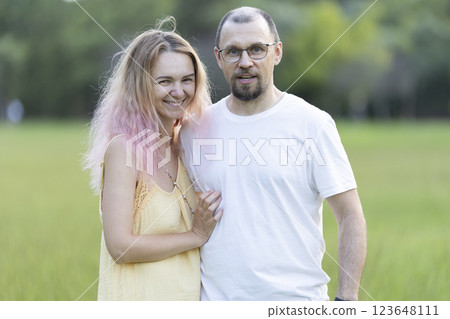 Happy couple smiling and embracing in green park Happy couple smiling and embracing in green park 123648111
