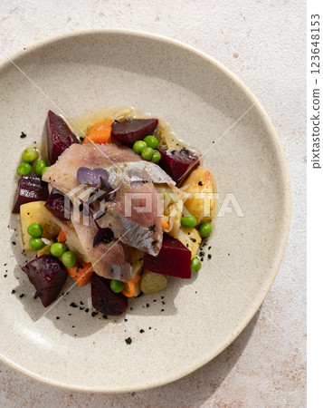 Restaurant dish with fish snack. Salted herring, potatoes, beets, carrots, green peas decorated microgreens. Pickled Herring Fish. Top view or flat lay 123648153