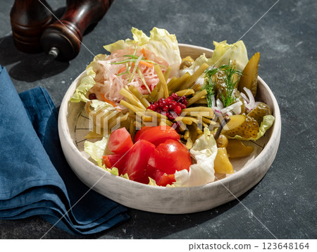Assorted snacks from fermented cabbage, cucumbers and tomatoes, green bean. Decorated cranberry. Fermented healthy food concept. Pickled cucumbers, marinated tomatoes 123648164