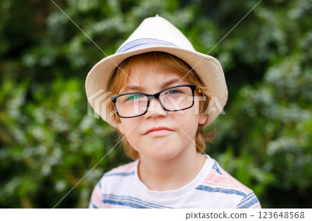 A portrait of a young boy with blonde hair, large glasses, and a straw hat A portrait of a young boy with blonde hair, large glasses, and a straw hat 123648568