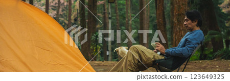 solo traveler in nature concept with asian man camping and work online with pink cherry blossom and pine tree in springtime season solo traveler in nature concept with asian man camping and work online with pink cherry blossom and pine tree in springtime season 123649325