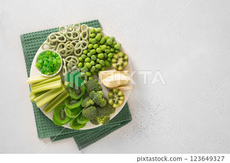 St Patricks day with charcuterie board and party decorations decorated shamrock on white background. View from above. Copy space. Festive holiday appetizer for celebration. St Patricks day with charcuterie board and party decorations decorated shamrock on white background. View from above. Copy space. Festive holiday appetizer for celebration. 123649327