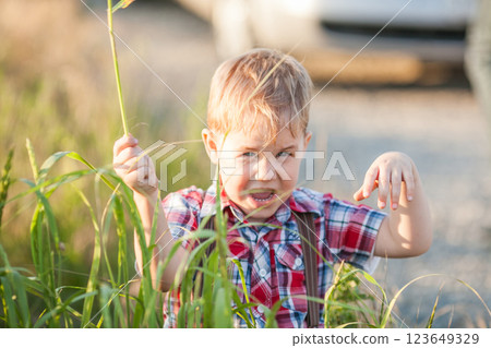 A little boy with strabismus is playing in a field during summer A little boy with strabismus is playing in a field during summer 123649329