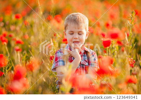 A little boy with strabismus plays in the field, exploring the plants A little boy with strabismus plays in the field, exploring the plants 123649341