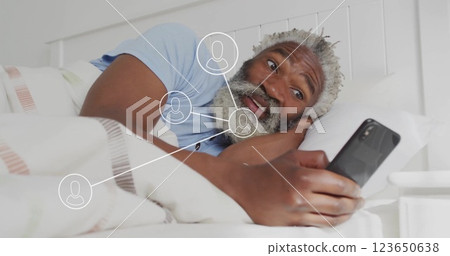 Image of network of connections with icons over senior african american man using smartphone 123650638