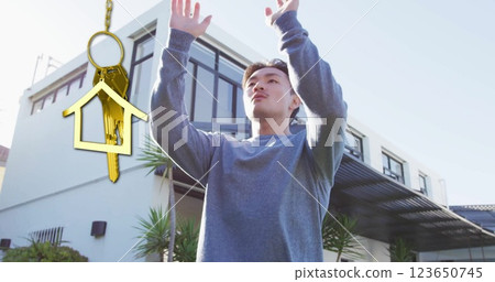 Image of gold house key and key fob over biracial man exercising by house 123650745