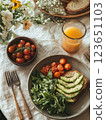 Fresh avocado toast with cherry tomatoes and arugula, served with orange juice. vibrant and healthy breakfast option, perfect for sunny morning 123651103