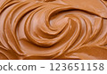 Creamy chocolate spread with smooth, swirled texture, perfect for desserts and snacks. Indulge in its rich flavor and velvety consistency 123651158