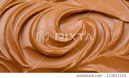Creamy chocolate spread with smooth, swirled texture, perfect for desserts and snacks. Indulge in its rich flavor and velvety consistency Creamy chocolate spread with smooth, swirled texture, perfect for desserts and snacks. Indulge in its rich flavor and velvety consistency 123651158