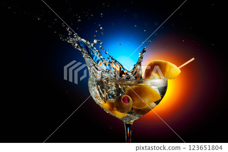 Lemon wedge falls into a martini glass. 123651804