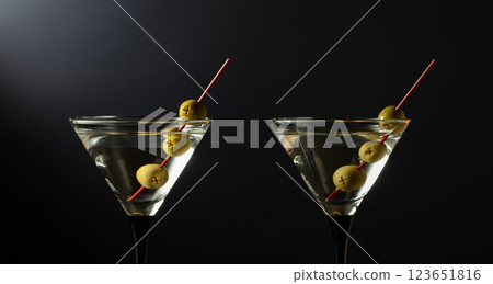 Glass of classic dry martini cocktail with lemon peel on a black background. Glass of classic dry martini cocktail with lemon peel on a black background. 123651816