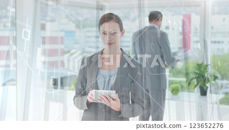 Image of financial data processing over caucasian businesswoman using tablet in office 123652276