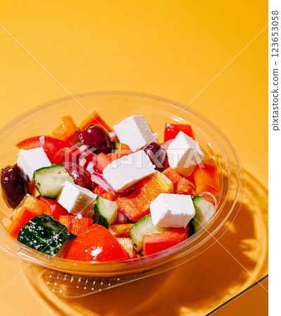 Fresh Greek salad with feta cheese and vegetables on orange background 123653058