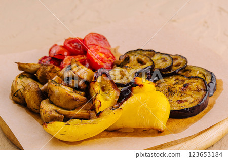Grilled vegetables on wooden board lying on parchment paper 123653184