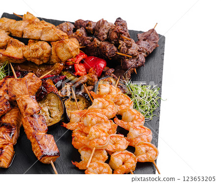 Delicious mixed grill platter featuring skewers of meat and seafood 123653205