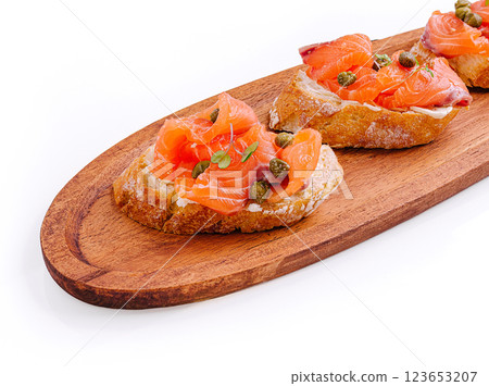 Delicious salmon bruschetta served elegantly on a wooden platter 123653207