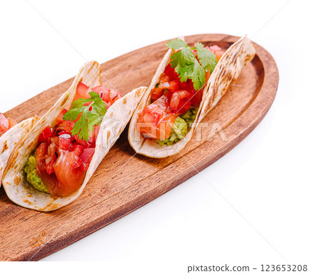 Delicious tacos served on a wooden platter with fresh toppings 123653208